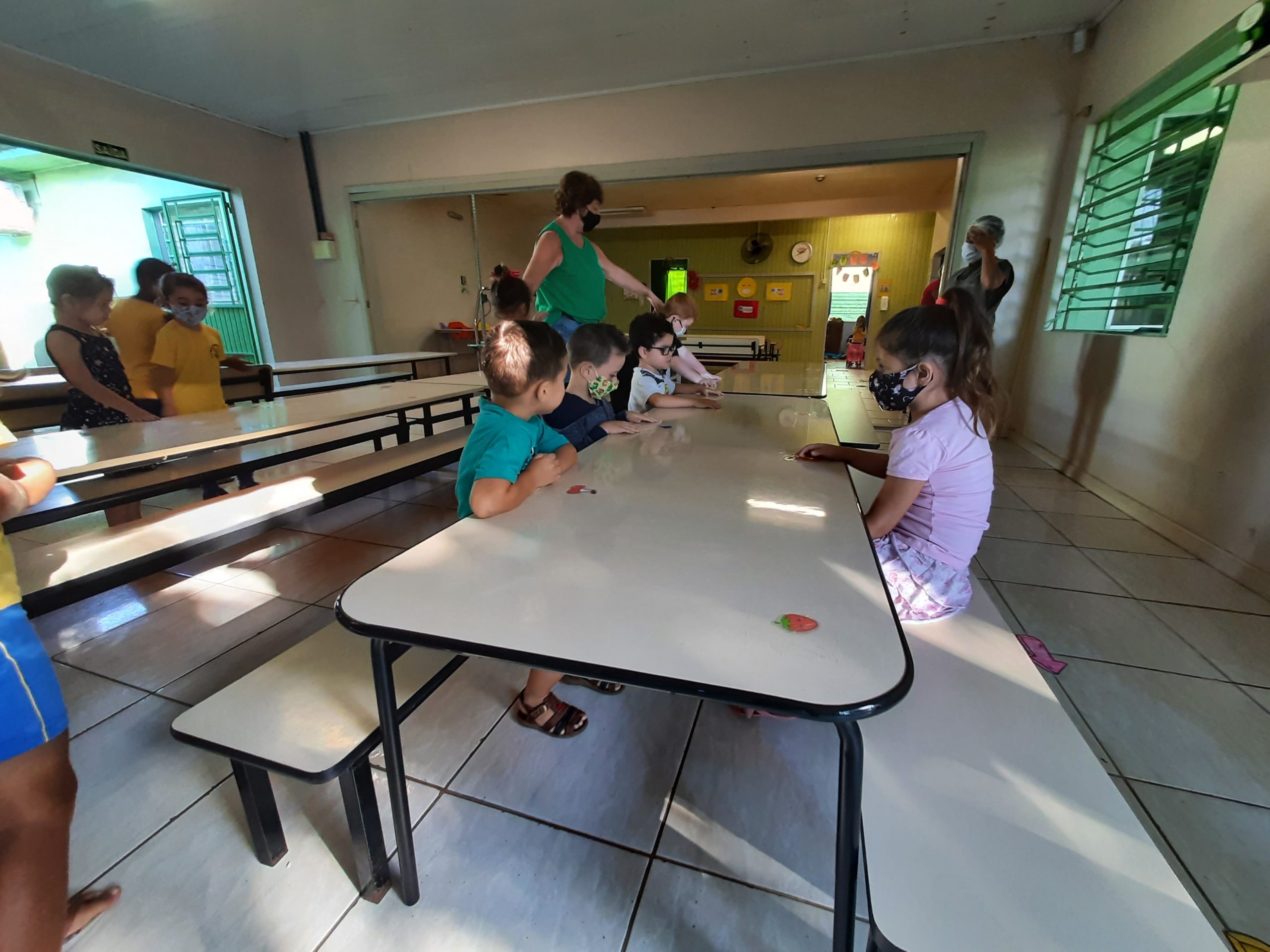 Lugares nas mesas foram demarcados com adesivos de frutas, para garantir o distanciamento entre as crianças