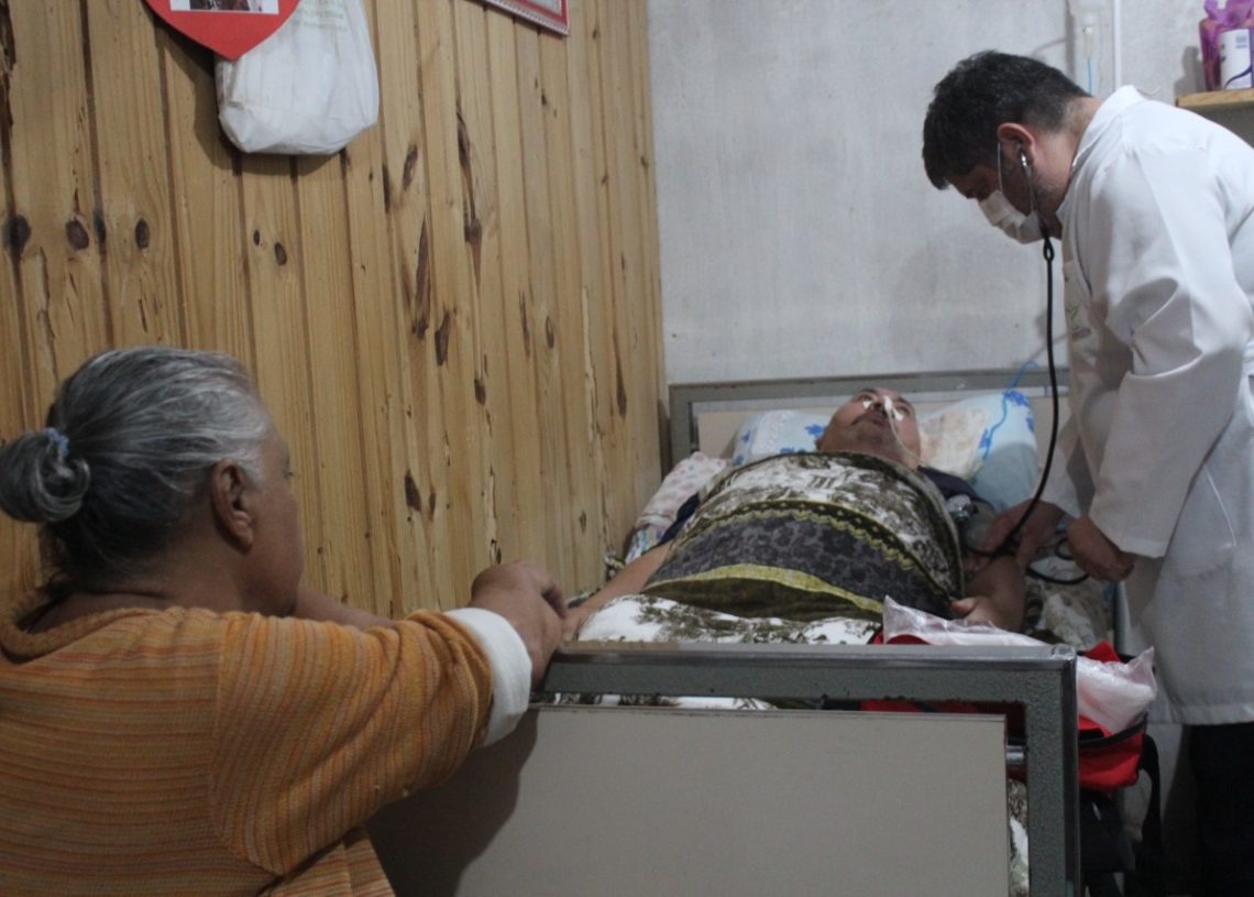 Enfermeiro Fábio 
atendendo o paciente Antônio Carlos da Silva, que está acamado, 
com o olhar atento da esposa Izaura 
(Fotos: Melissa Costa)