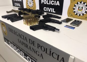 Pistolas, adaptadores de submetralhadora, munições de fuzis e celulares apreendidos (Foto: Melissa Costa)